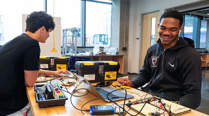 Two Carnegie Mellon students working on circuitry in a lab.